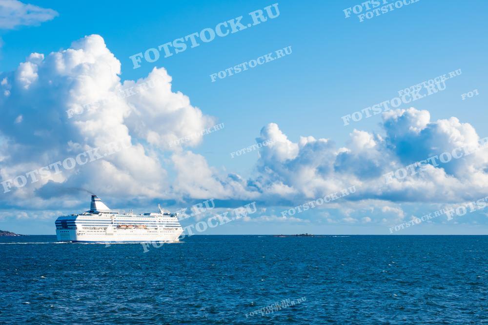 Фотография круизного лайнера, плывущего в открытом море на фоне облачного неба. Сцена подчеркивает красоту и масштаб морских путешествий.